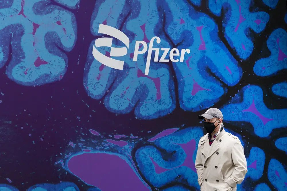 A man walks by Pfizer headquarters, Friday, Feb. 5, 2021, in New York. Pfizer will spend about $43 billion to buy Seagen and broaden its reach into cancer treatments, the pharmaceutical giant said Monday, March 13, 2023. (AP Photo/Mark Lennihan, File)